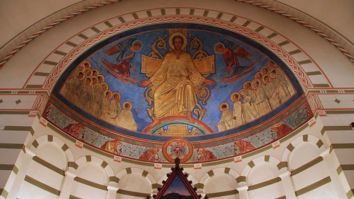 Billedet viser indersiden af en kirke med en stor, udsmykket kuppel.