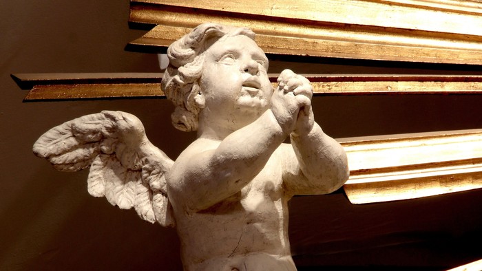 En lille engelstatue med vinger og horn.