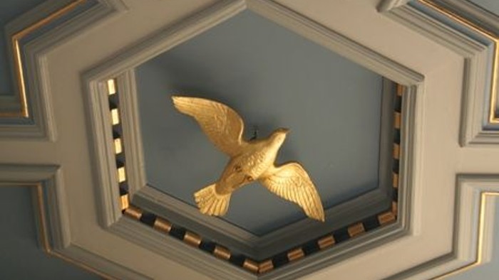 Gul fugl i blå og gyldne indramning på tak