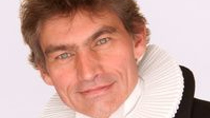 En mand med hvid krage og sort kappe.