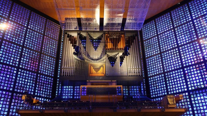 Großes Kirchenorgel vor farbigem Glasfenster
