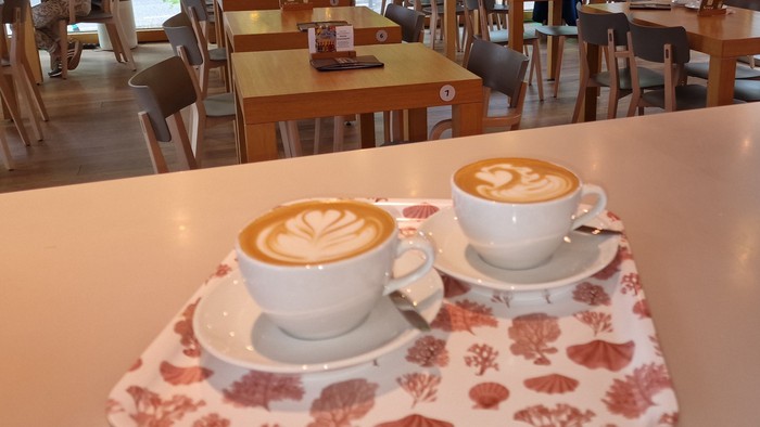 Zwei Kaffeetassen auf einem Tablett in einem Café