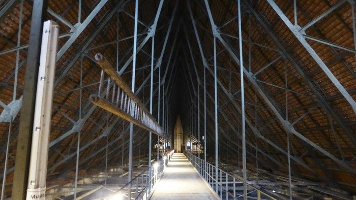 Ein großer, leerer Raum mit Metallträgern und Holzboden.