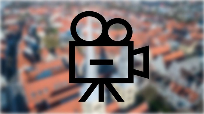 Ein Kamerasymbol vor unscharfem Stadtbild