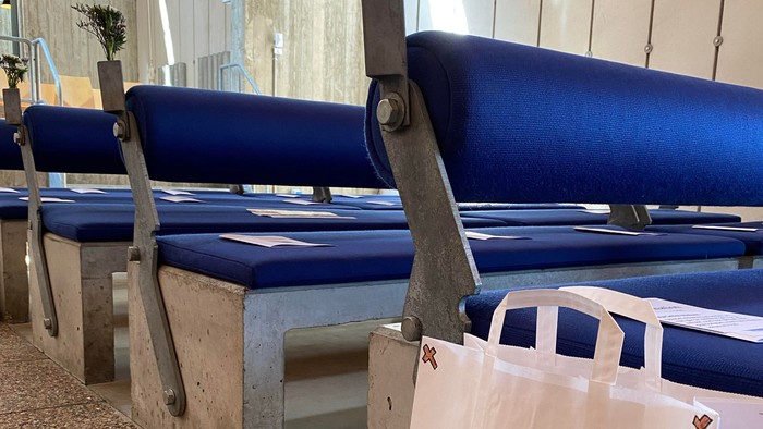 Blå bænke med blomster og hvid plasttøj på kirkegård