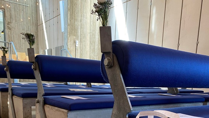 Blå bænke med blomster og hvid plasttøj på kirkegård