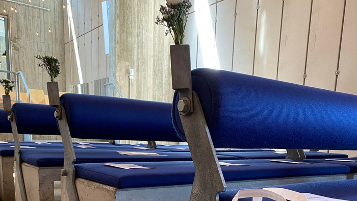 Blå bænke med blomster og hvid plasttøj på kirkegård