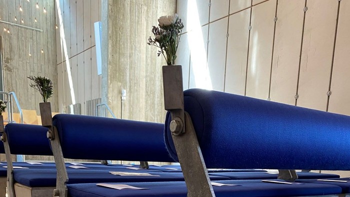 Blå bænke med blomster og hvid plasttøffel med kors og hjerte