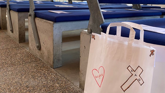 Blå bænke med blomster og hvid plasttøj på kirkegård