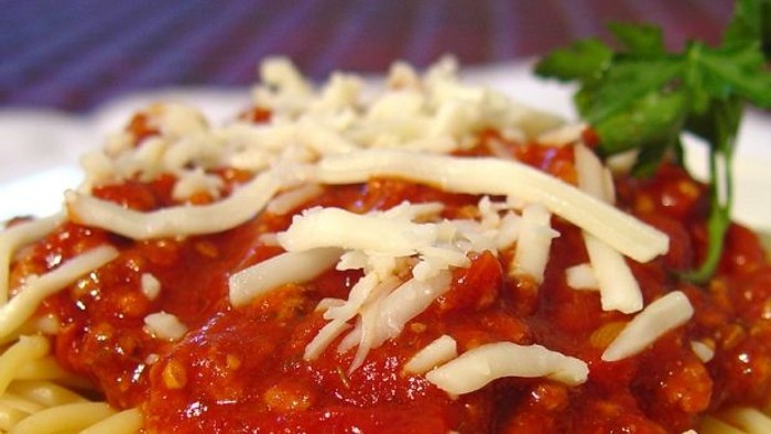 En ret spaghetti med tomatsaus og ost.