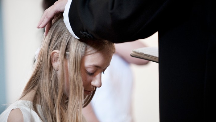 En kvinde får sit hår stillet af en frisør.