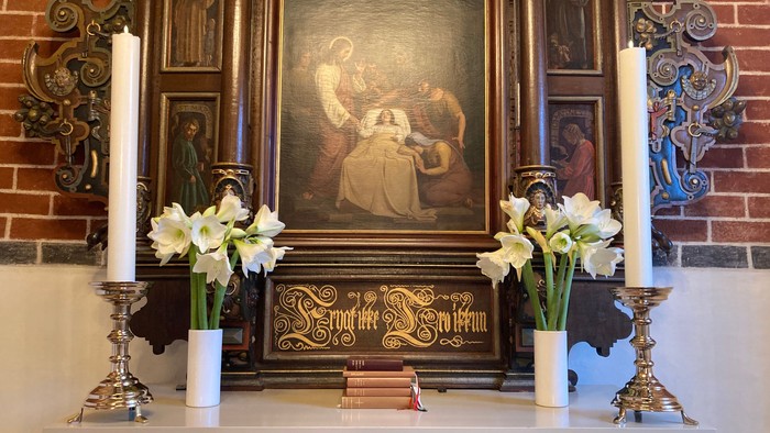 Altaret i kirken med blomster og billede af Jesus