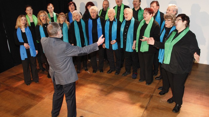 Ein Chor proben unter der Leitung eines Dirigenten