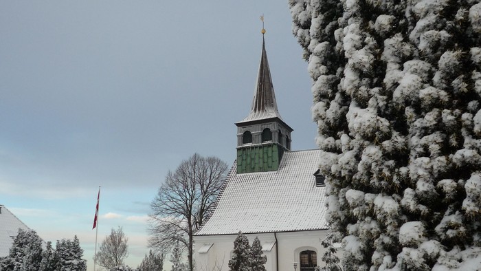 Snefaldt på kirke og træer i landsby