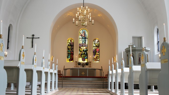 Indenrig af kirke med alter og glasmalerier