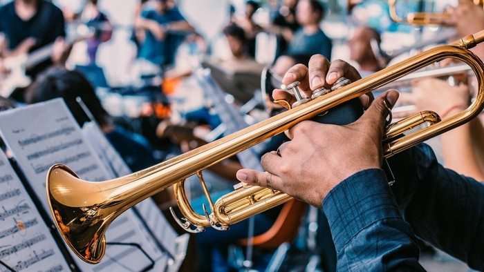 Musiker, die in einem Orchester Blechblasinstrumente spielen.