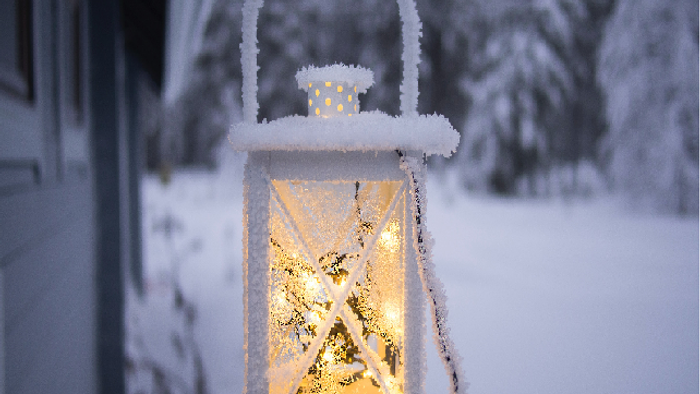 En lysende lykt dækket af sne i vinterlandskab