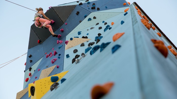 En person klatrer en farverig klatretårn.