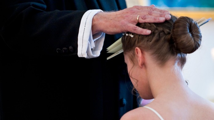 En kvinde får sit hår stillet af en frisør.