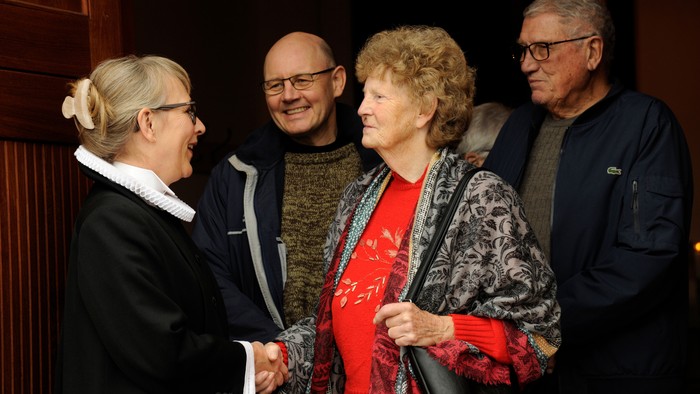 En gruppe af fire personer står sammen og smiler.