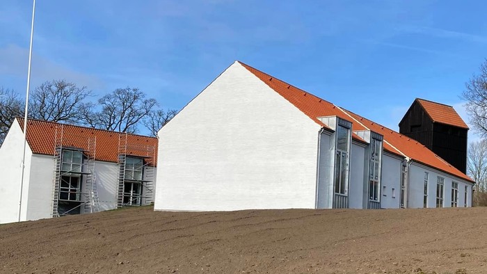 Hus med røde tag og græsplæne