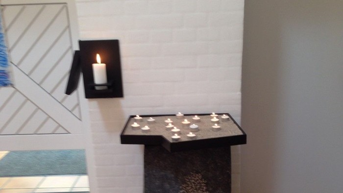 En sort bord med lys på et hvide væg.