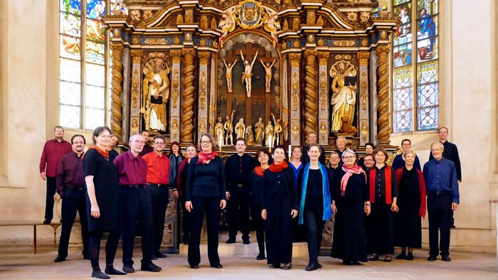 Eine Gruppe von Menschen posiert vor einem verzierten Altar in einer Kirche