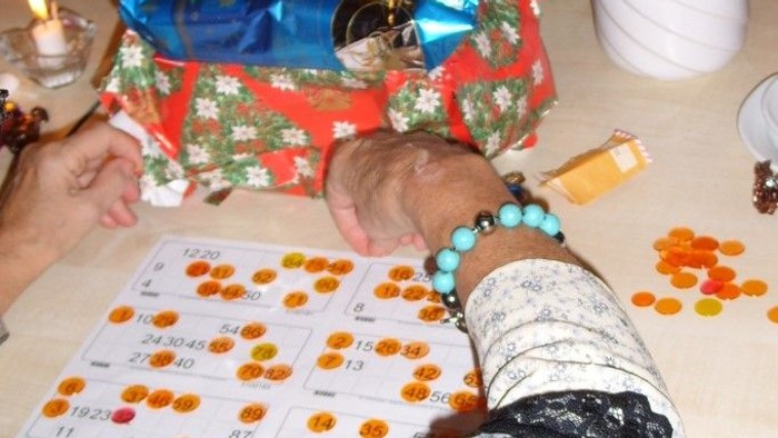 En person sidder ved bord med pakker og gaveemballage