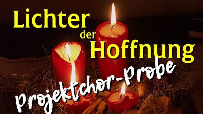 Drei brennende Kerzen auf Stroh mit Weihnachtsbezug