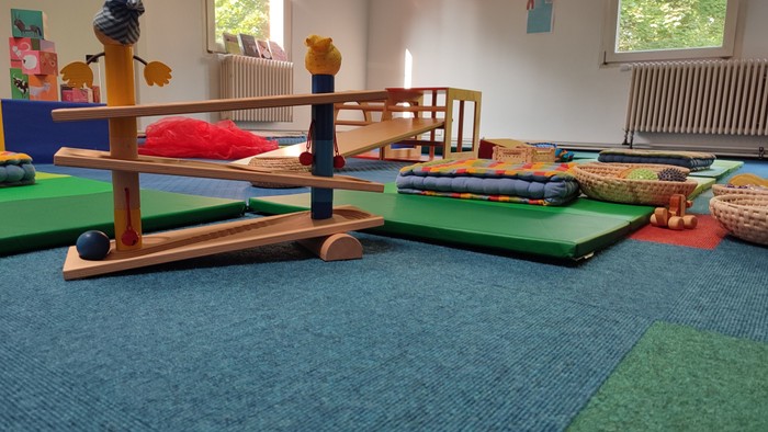 Ein Kinderzimmer mit Spielzeug und Matten auf dem Boden