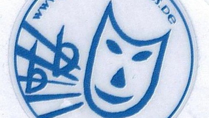 Das Aufkleber zeigt ein Theater-Masken-Logo und eine Website-Adresse.