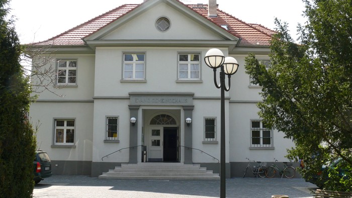 Zwei-stöckiges weißes Gebäude mit Treppe und Laterne davor