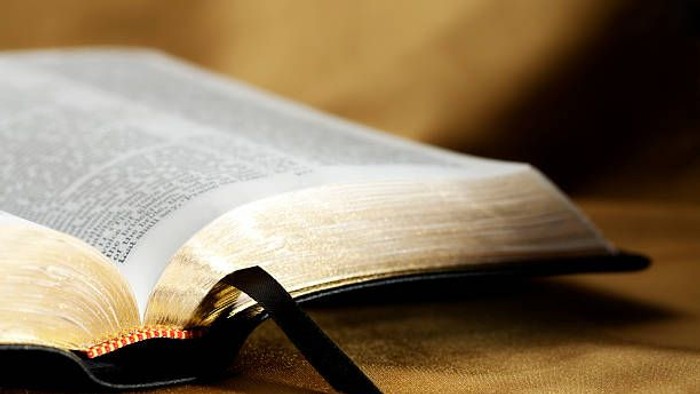 Offenes Buch mit Lesezeichen auf goldenem Stoff