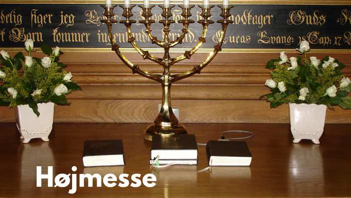 En højmesse med blomster og lysestage