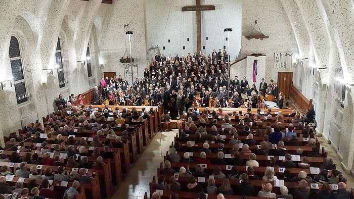 Große Kirchengemeinde bei einem Gottesdienst in einer prächtigen Kirche.