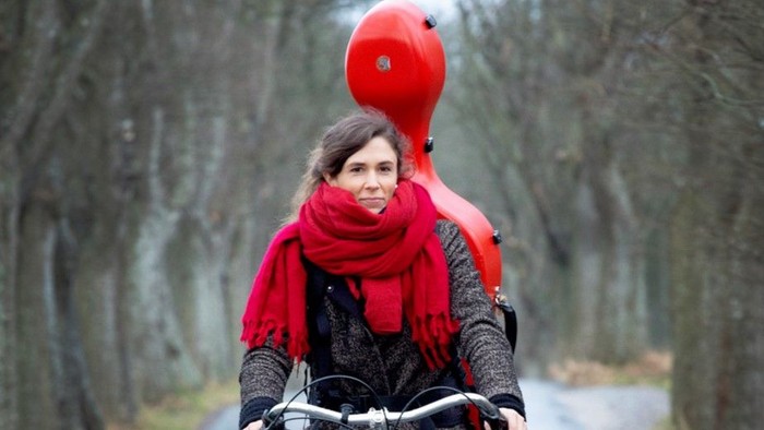 Kvinde cykler med rød pibe på hovedet.