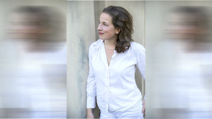 Frau in weißem Hemd vor weißer Wand