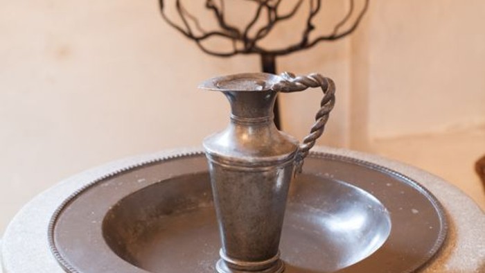 En smuk porslinfontæne med en lille kande og blomst.