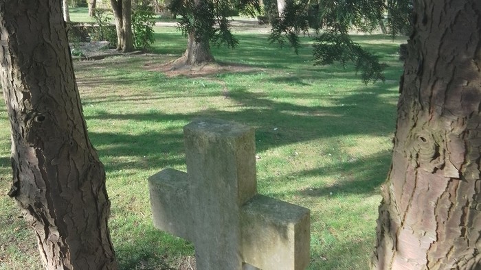 En grav med et kors i en park.