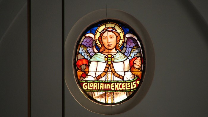 Stained glass vindue med portræt af en helgen og latinsk tekst