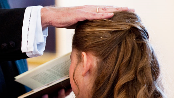 En mand holder en bog op for en kvinde, der ser på.