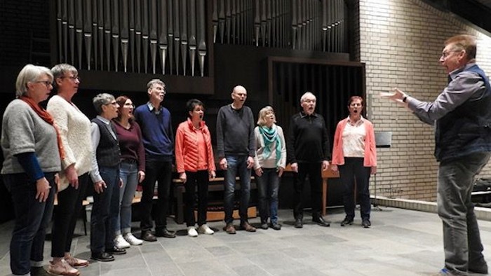 Eine Gruppe von Menschen hört einem Mann in einem Kirchenraum zu
