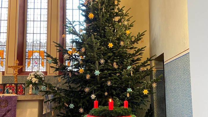 Weihnachtsbaum in der Kirche mit Kerzen und Dekorationen