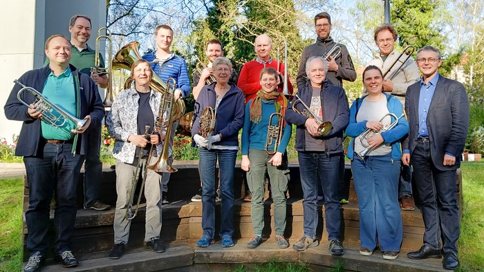 Eine Gruppe von Musikern posiert mit ihren Instrumenten im Freien