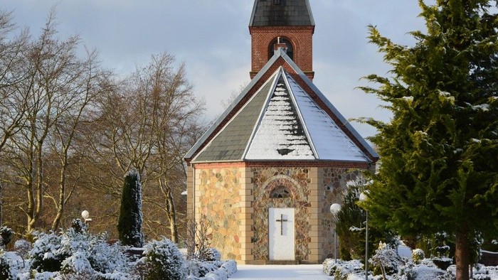 En lille kirke med tårn i sneklædt landskab