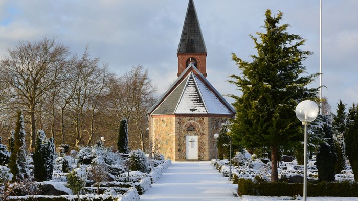 En lille kirke i sneklædt landskab