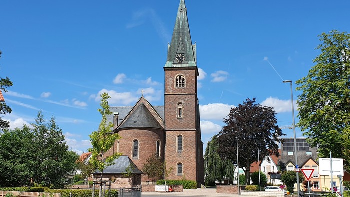 Kirchengemeinde mit hohem Turm und grünem Dach in ruhiger Umgebung