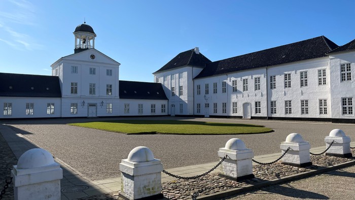 Det store, hvide slot med klokketårn og mange vinduer.