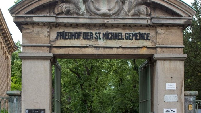 Eingangstor zur Friedhof der St. Michael Gemeinde, mit Kreuz und Graffiti