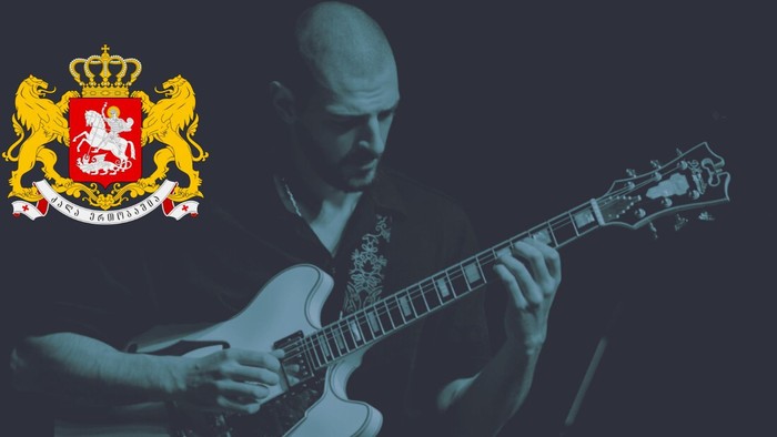 En bald mand spiller guitar i en mørk scene med et kongeligt vapen.